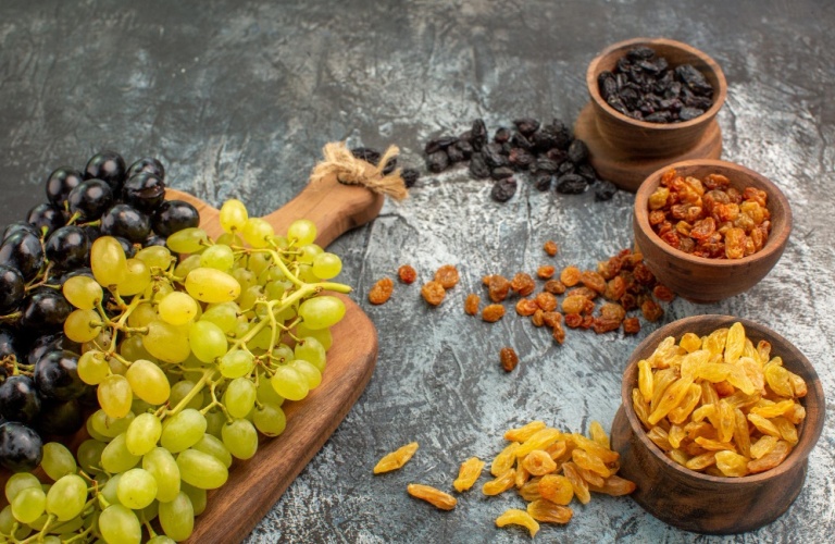 side-close-up-view-dried-fruits-dried-fruits-brown-bowls-grapes-wooden-board